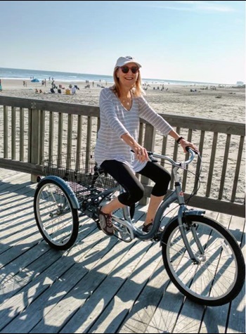 Breast cancer patient Susie Krupnick riding her bike at the beach